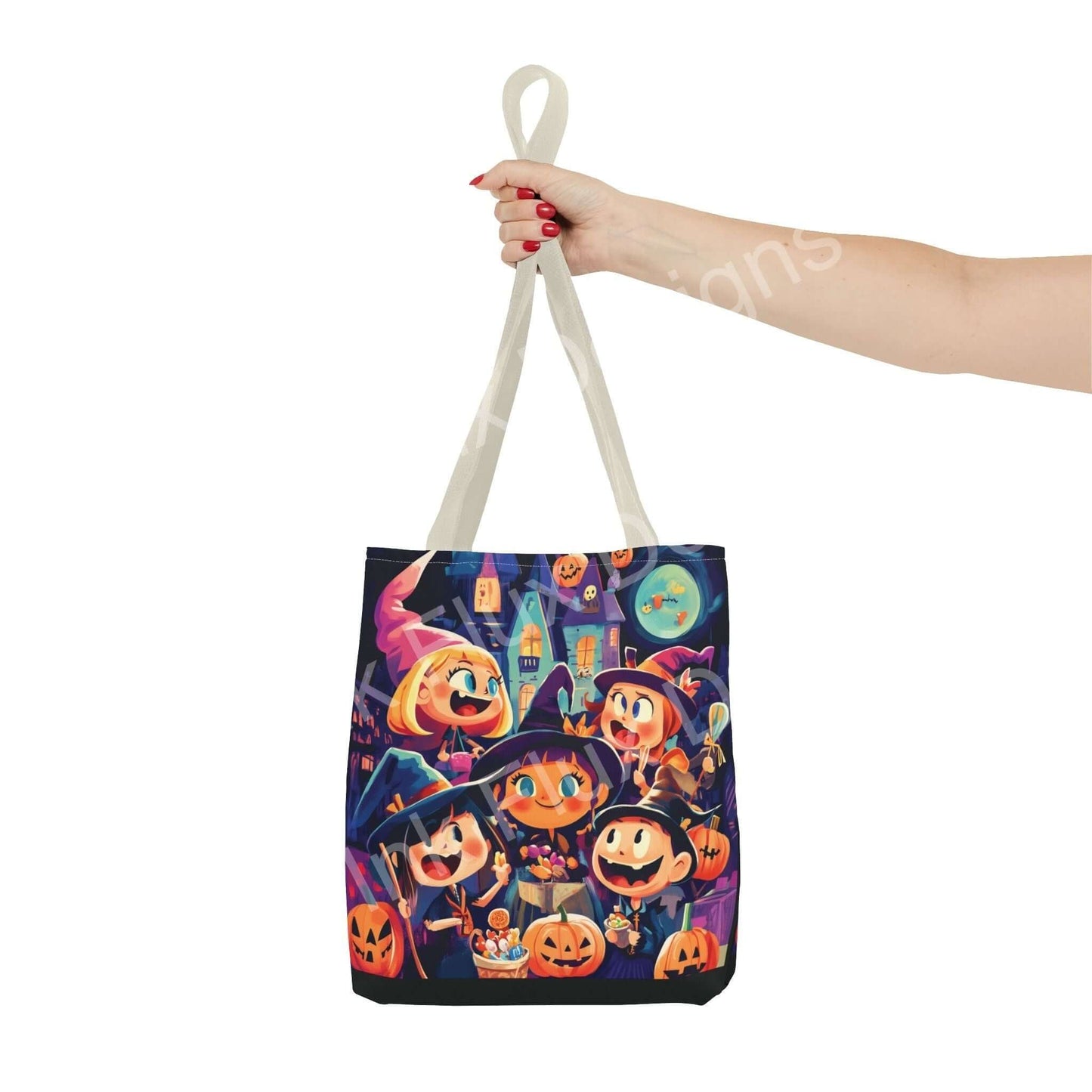 Woman's hand holding a Little Witches themed tote bag with colorful all-over print design, featuring playful witch and pumpkin illustrations.