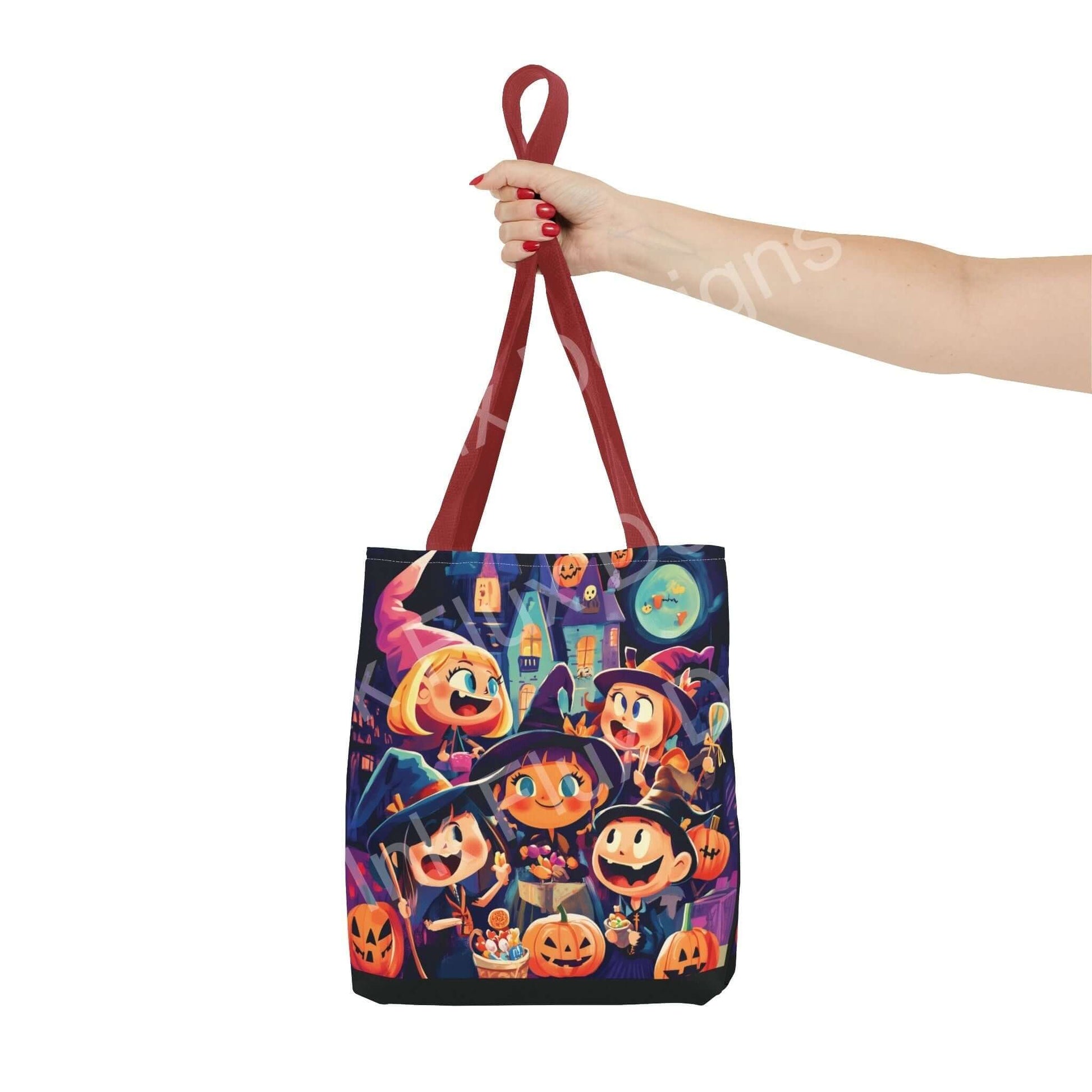 Stylish Little Witches all-over print tote bag with red handles held by a hand, featuring playful Halloween-themed design, durable polyester fabric.