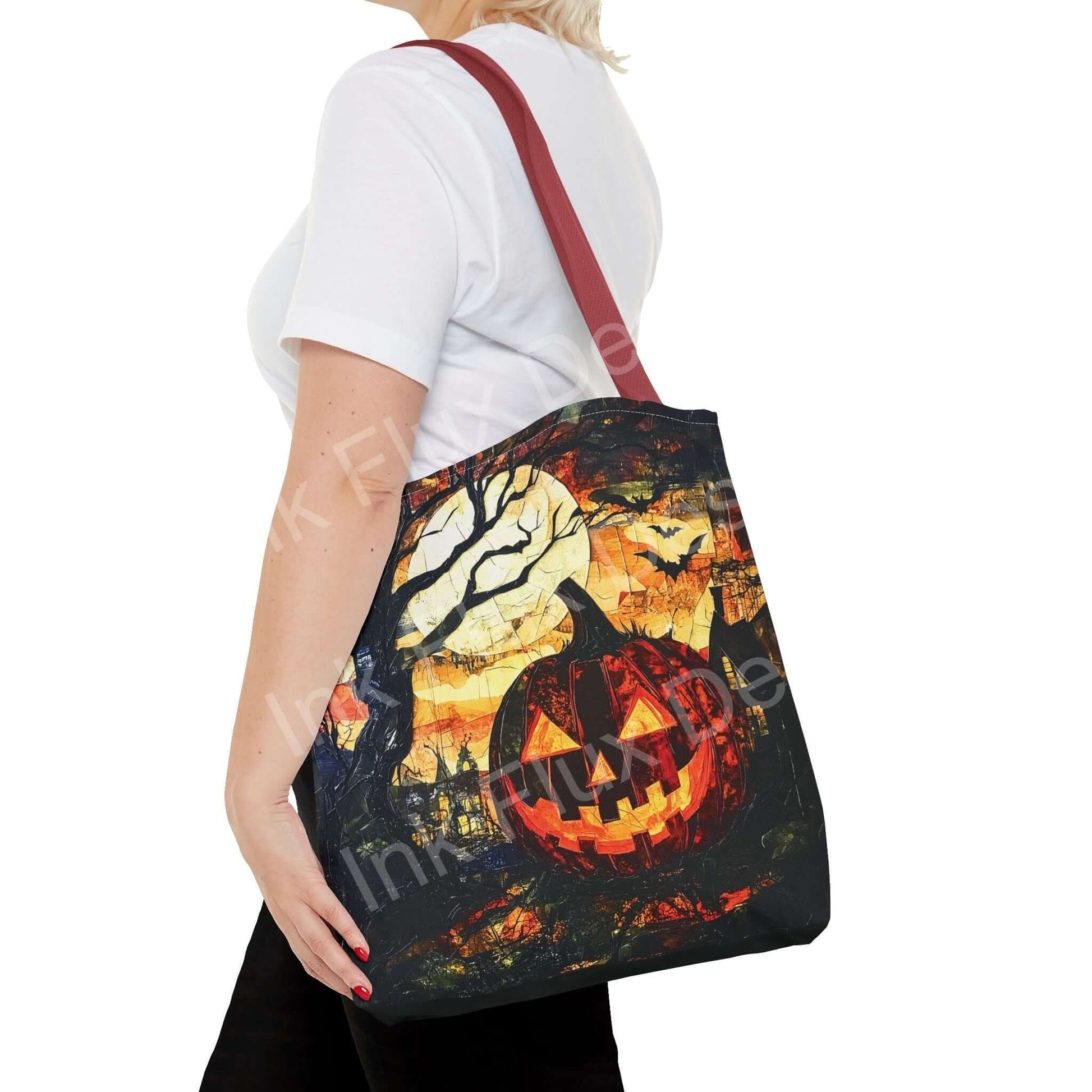 Woman wearing a white shirt carrying a Jack o' Lantern painting tote bag with red strap, featuring a vibrant Halloween-themed all-over print.