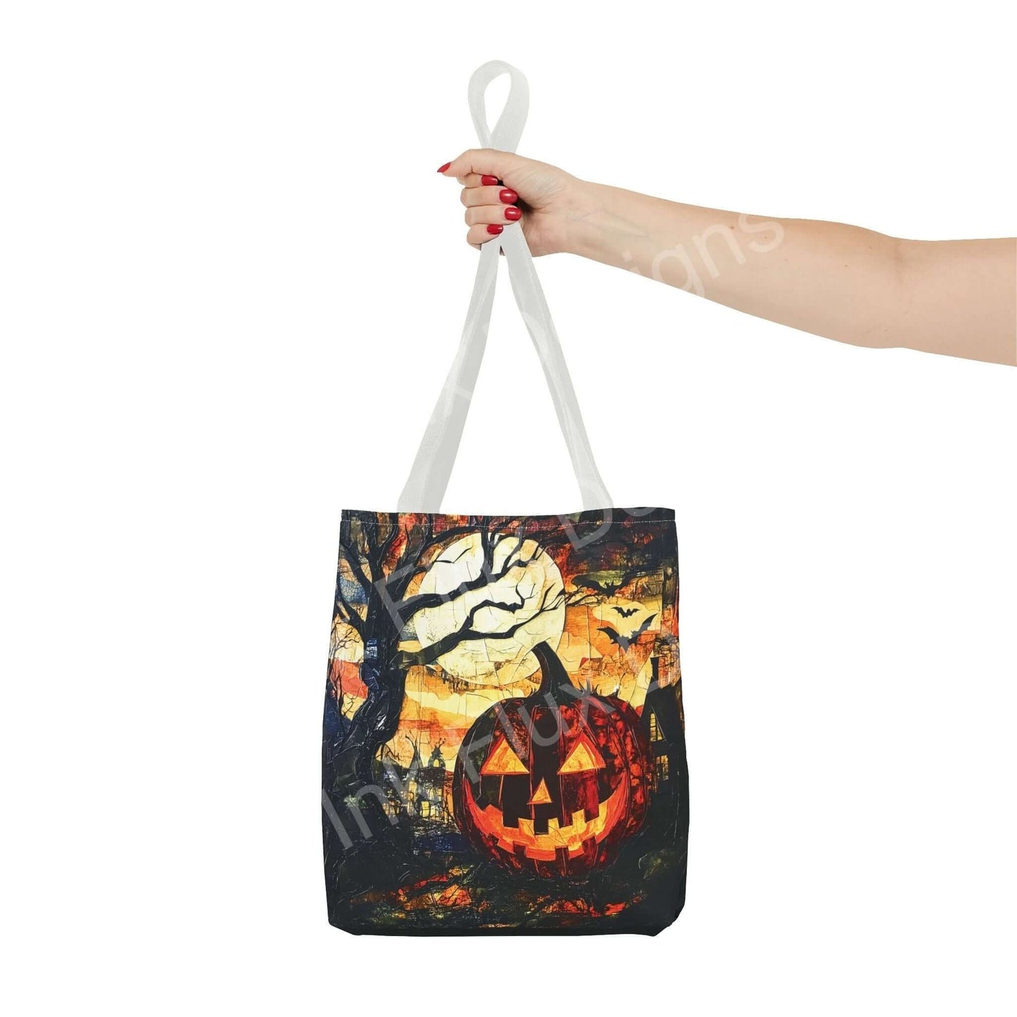 Hand holding a Jack o Lantern painting tote bag with a vibrant, all-over print featuring a pumpkin, moon, and bats, perfect for Halloween.