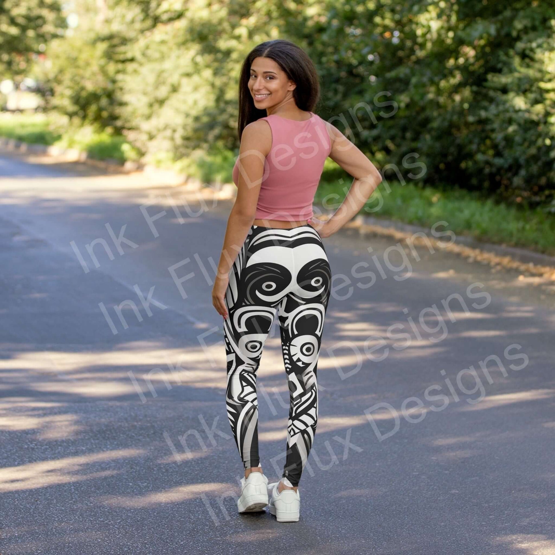 Woman in pink top and bold-designed Trippy VIII leggings smiling on a sunny street, showcasing the stylish back view of the stretchy, durable athleisure wear.