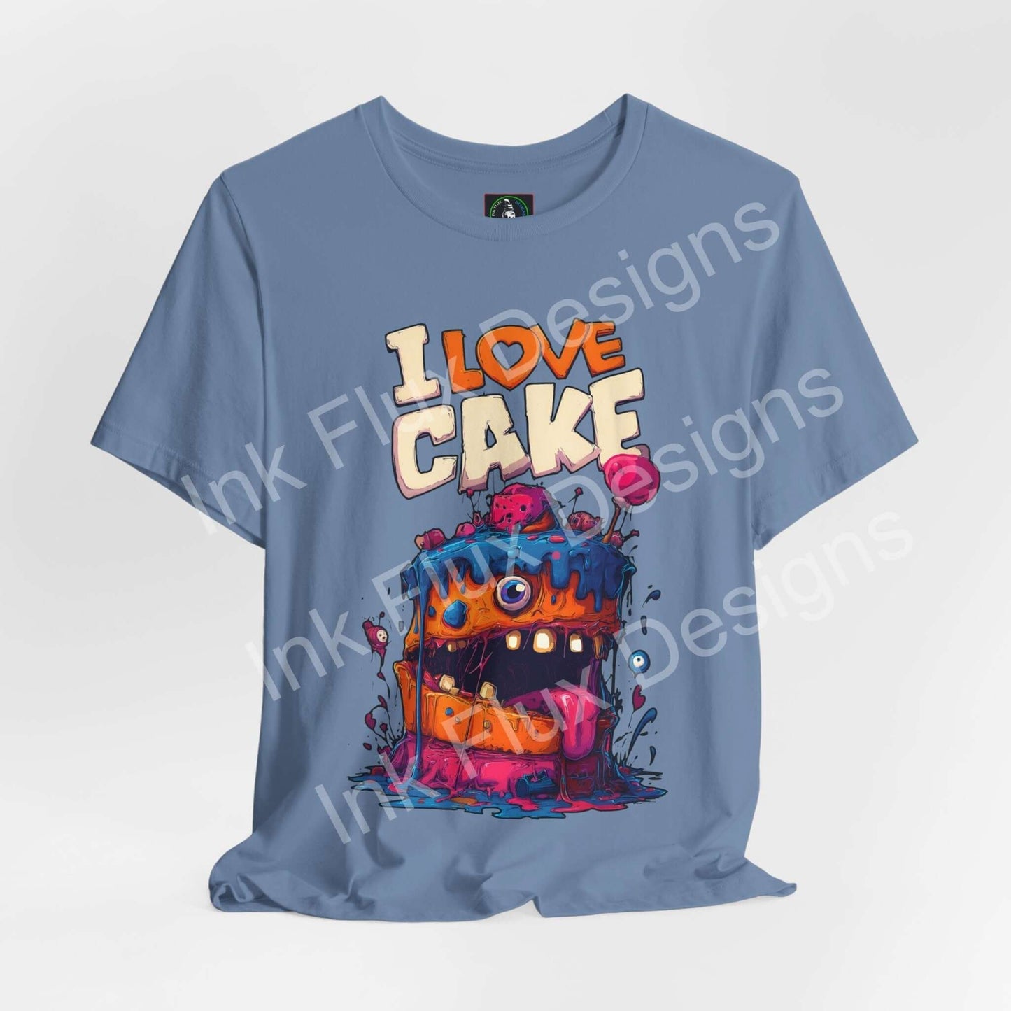 Funny Graphic T-Shirt featuring a colorful monster cake design with oversized eyes and dripping icing.
