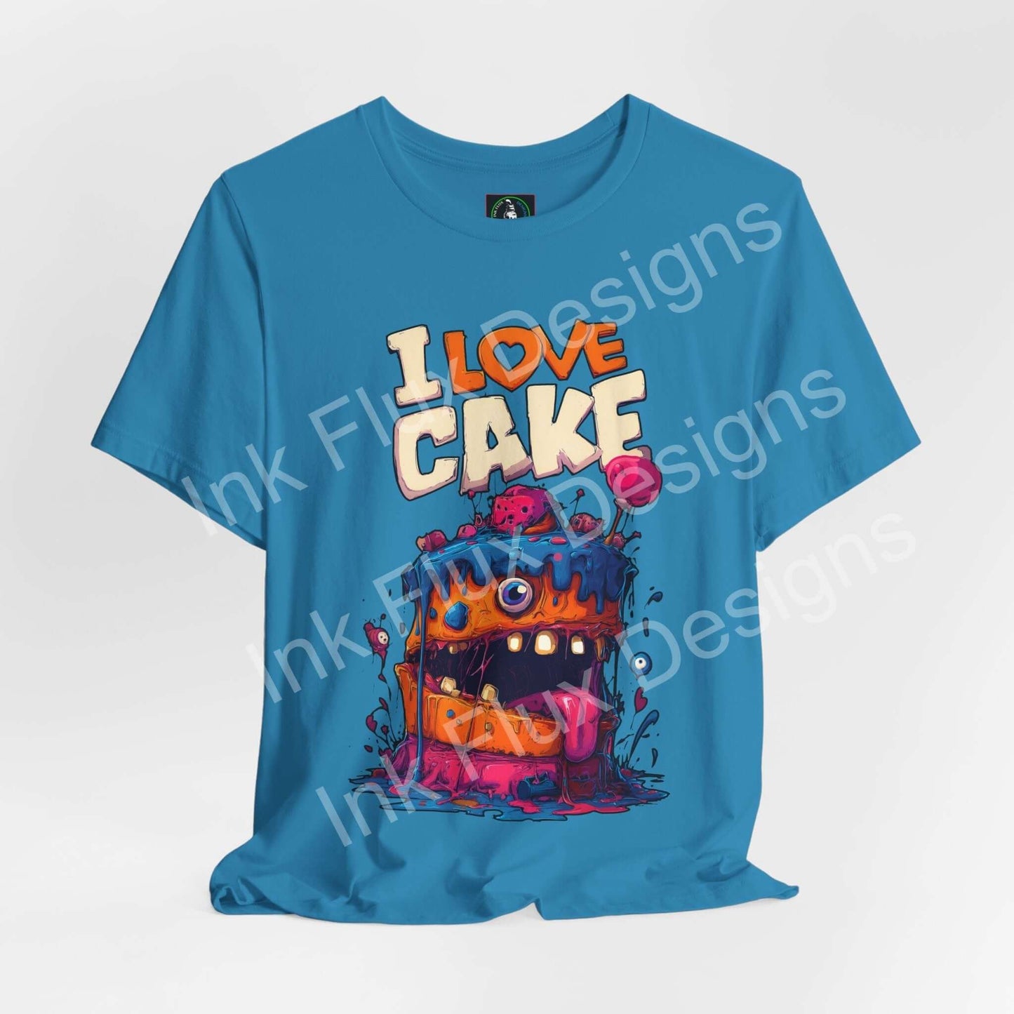 I Love Cake II Funny Graphic T-Shirt features a colorful monster cake design with cartoon art on a blue tee.