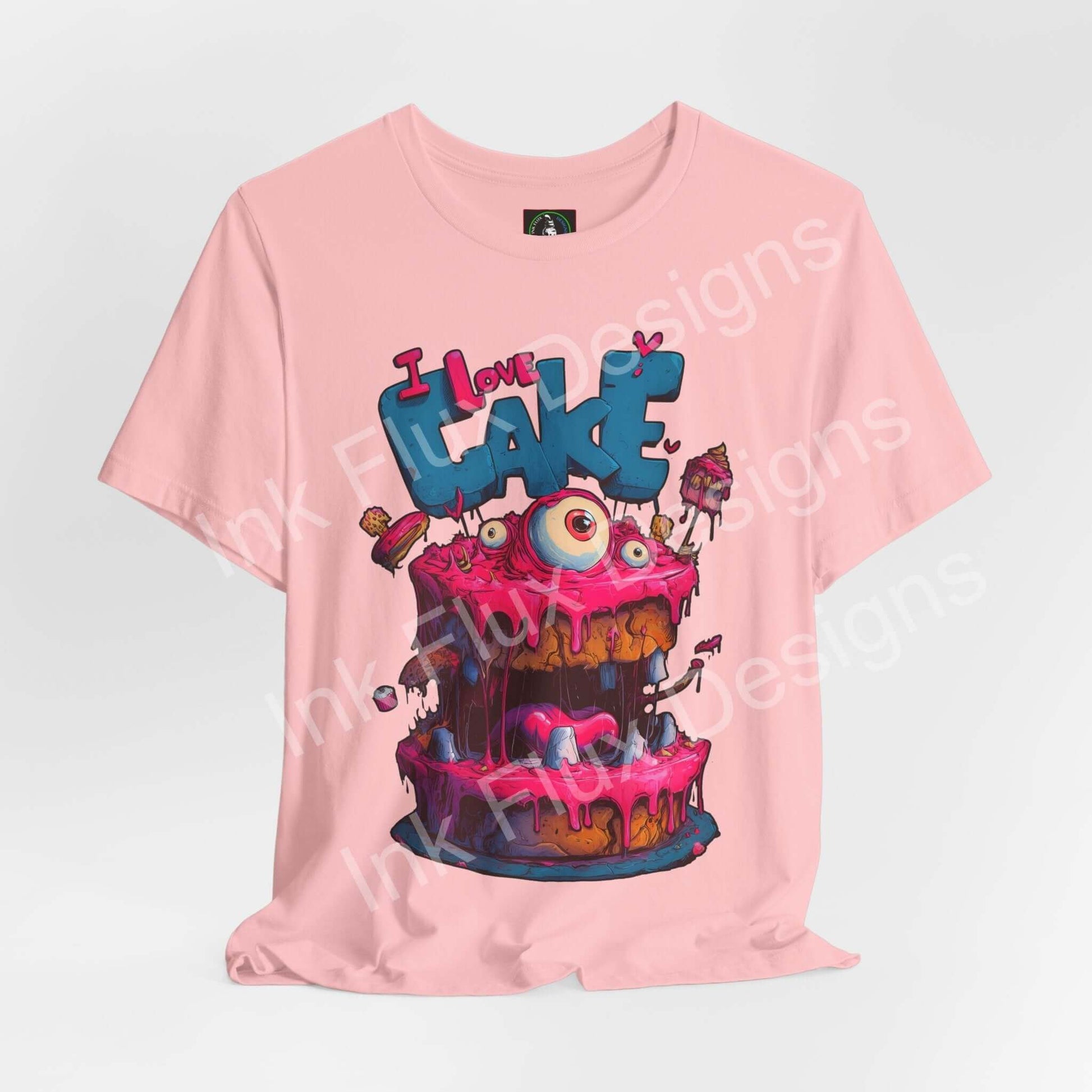 Funny Graphic T-Shirt featuring a colorful monster cake design with oversized eyes and pink icing.