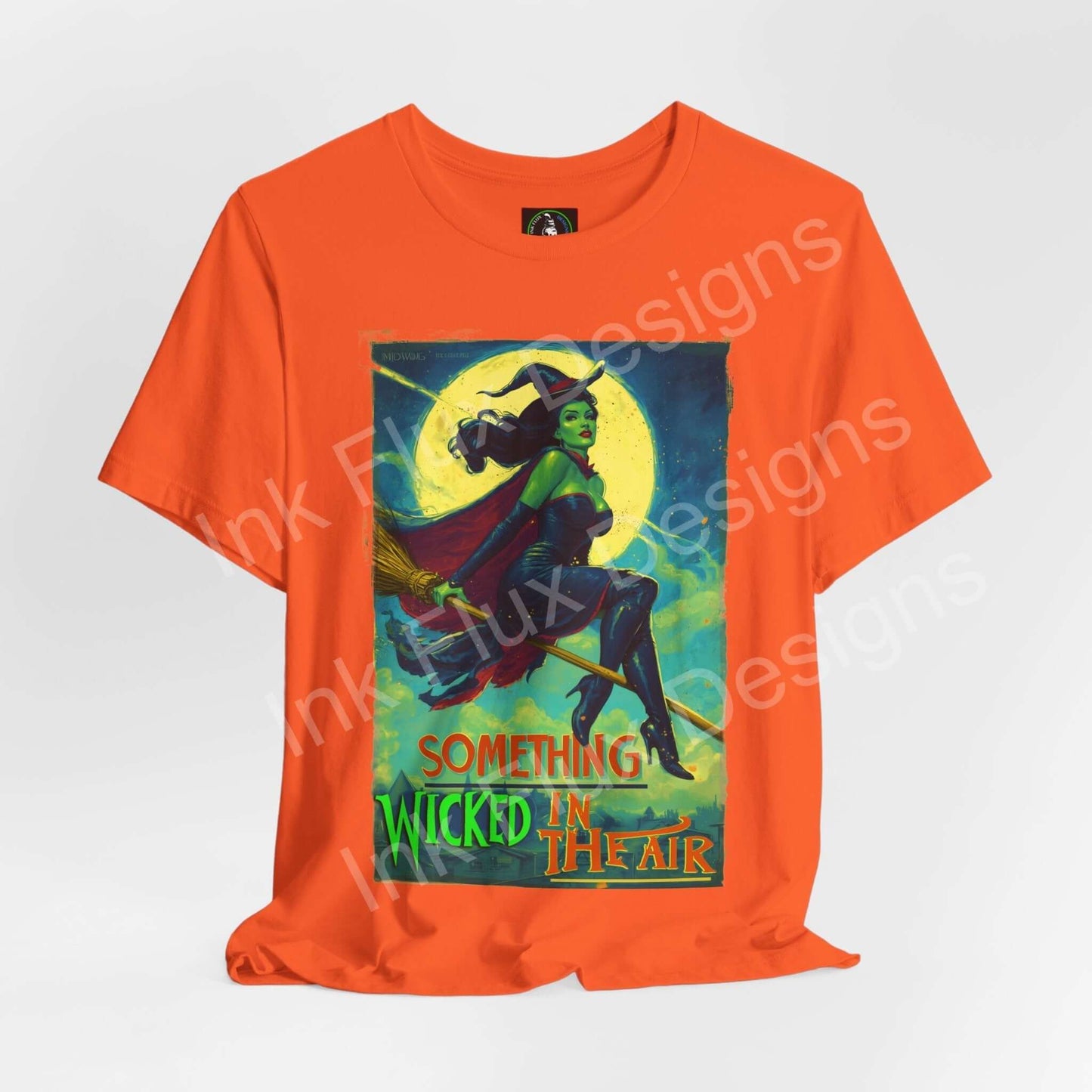 Halloween witch t-shirt featuring the phrase 'Something Wicked in the Air' on an orange background.