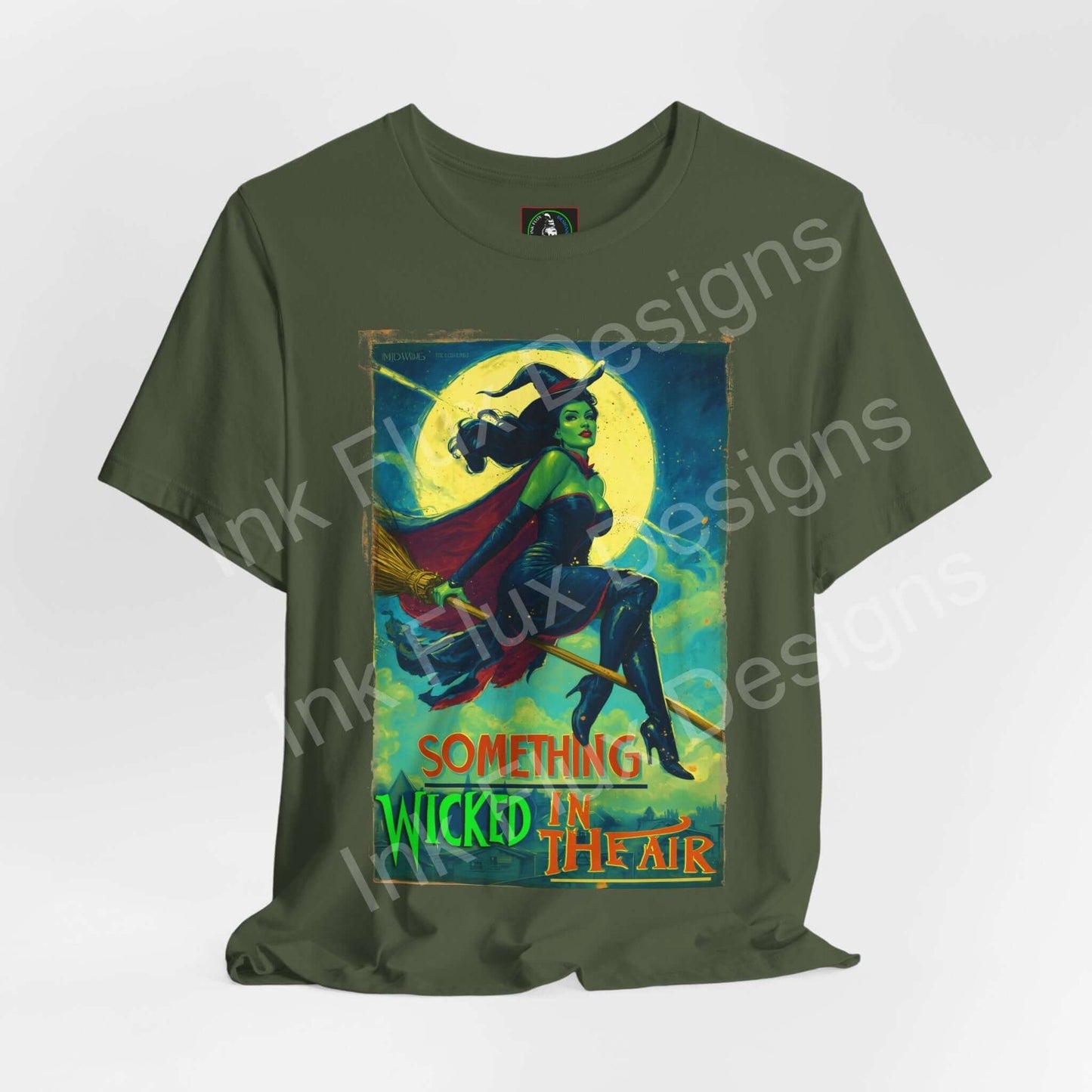 Halloween witch t-shirt featuring the phrase "Something Wicked in the Air" on a green background.